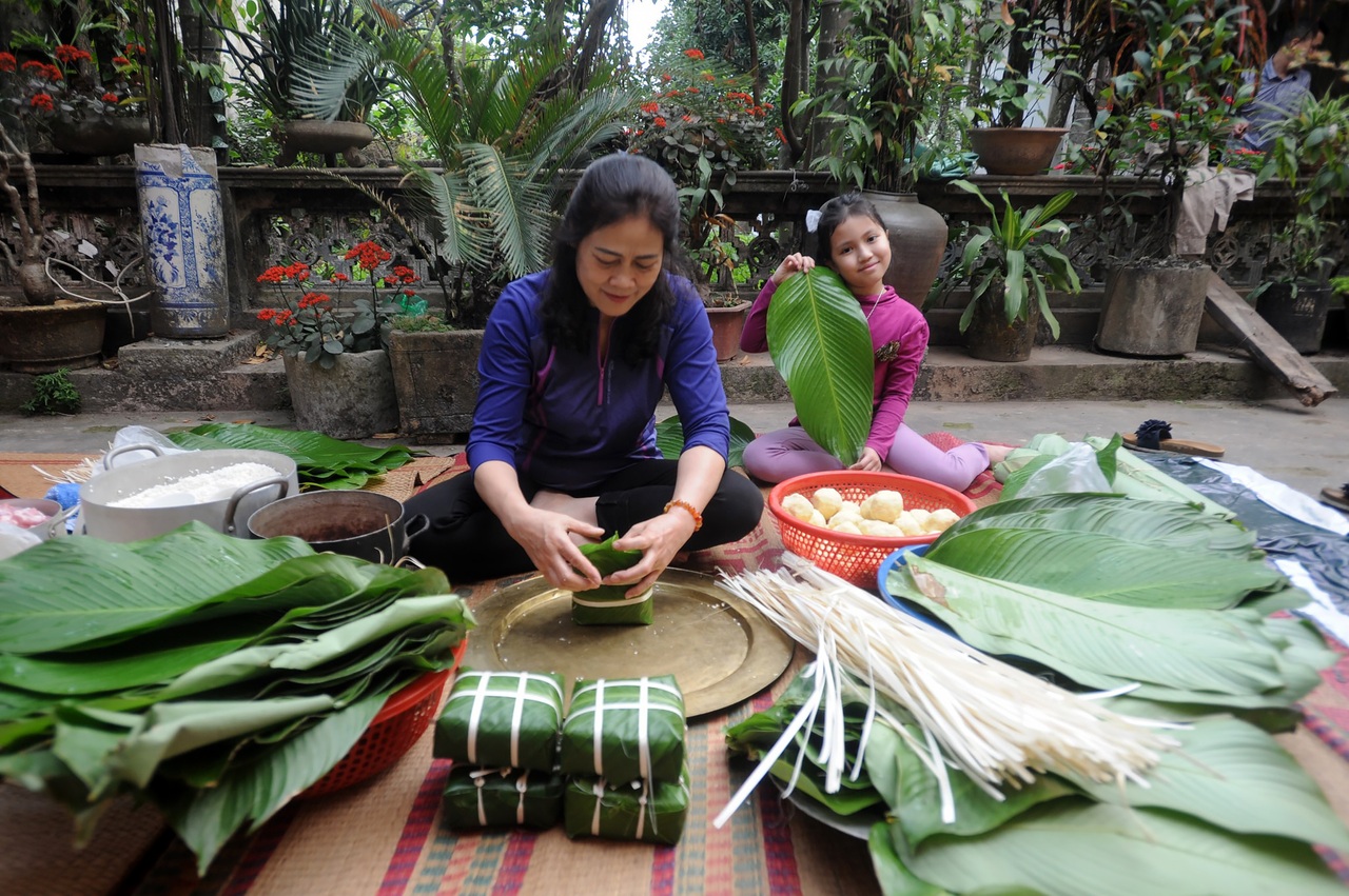 Đại gia đình thế hệ về quê quây quần bên nhau gói bánh chưng đón Tết