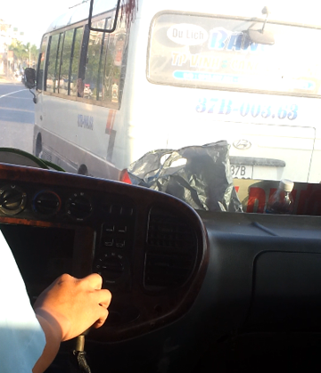 Đang dừng đón khách, chiếc xe bất ngờ rẽ sang trái để chèn không cho xe buýt đi sau vượt lên