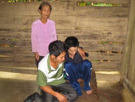 Người mẹ khóc cạn nước mắt vì thương con - 3 Người em trai bị bệnh tâm thần đã được xích chặt vào cột nhà (mặc quần xanh)