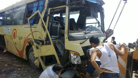 Chiếc xe khách hư hỏng nặng, được lực lượng cứu hộ kéo lên lề đường sau tai nạn