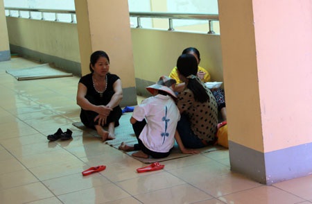 Mệt lử người với trận nắng gắt đầu mùa - 8 Người nhà bệnh nhân mang chiếu ra sảnh bệnh viện để hóng mát