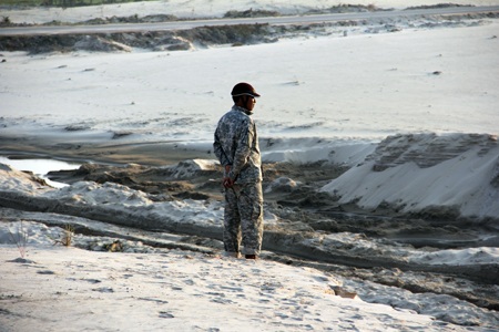 Một bảo vệ canh gác bãi cát cho đầu nậu