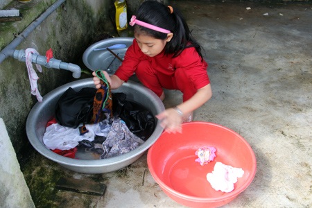 Cô bé làm việc như người lớn, giặt cả chậu đồ khi mẹ ốm bố vắng nhà