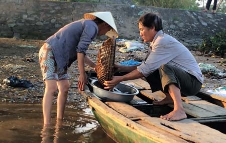 Lãng ngư Đào Xuân Khuyên đưa mớ cá kiếm được lên cho vợ bán ngay chợ cóc trong làng