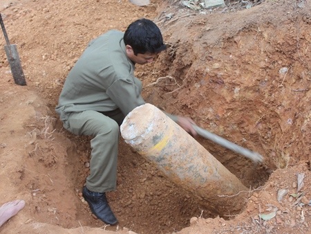 Mở đường lên chùa, phát hiện quả bom 125kg - 1 Lực lượng chức năng đào khoét đất trước khi tời quả bom lên khỏi mặt đất (ảnh: Lê Quyết)