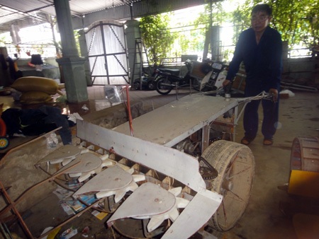 Ông Hải bên chiếc máy gặt do mình tự mày mò, sáng chế