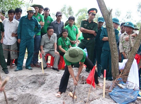 Cậu
Thủy (áo trắng xám, ngồi) chỉ đạo đoàn tìm kiếm cất bốc hài cốt.