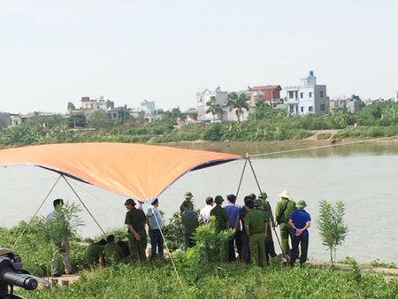 Chồng đập vỡ sọ vợ, nhét vào bao tải thả trôi sông - 1 Lực
lượng chức năng đang khám nghiệm tử thi sau khi vớt được thi thể nạn nhân - Ảnh:
CAND