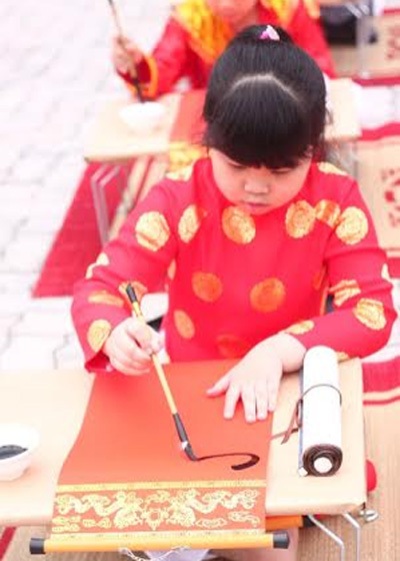 Ngắm 50 “ông đồ, bà đồ nhí” viết thư pháp - 5 “Bà đồ nhí” uốn nắn từng nét thư pháp.