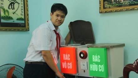Thùng rác “biết nói” của cậu học trò lớp 9 - 1 Nguyễn Viết Gia Khải bên sản phẩm “Thùng rác thông minh” của mình. (Ảnh: Thanh Trần