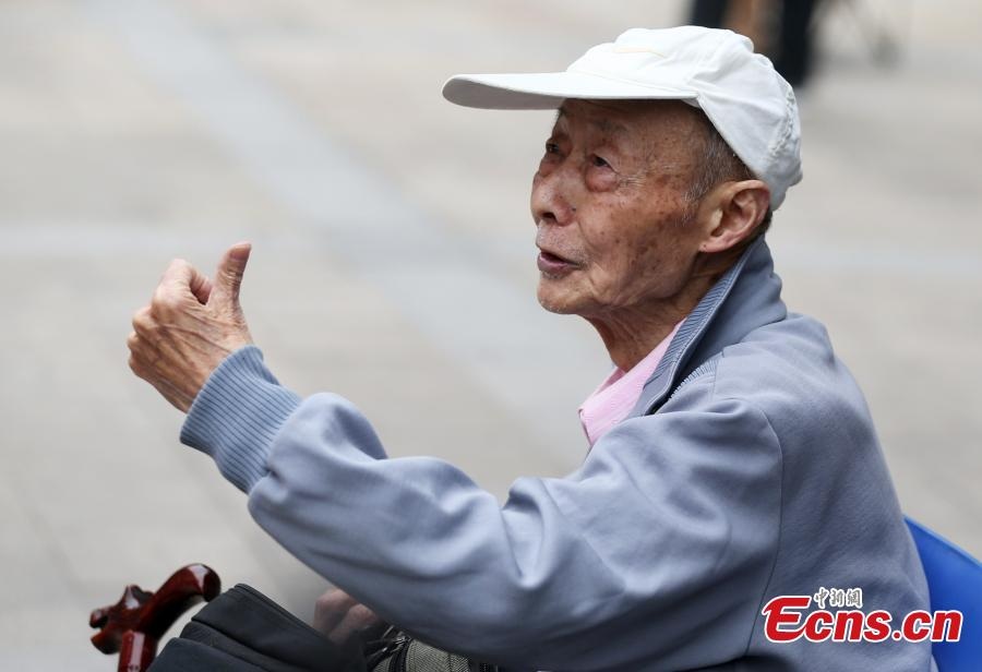 Cụ ông 86 tuổi 15 lần đi thi đại học - 4 Cụ ông 86 tuổi làm dấu hiệu chiến thắng trước khi vào phòng thi.