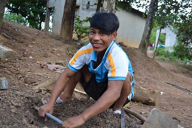 Cậu bé Raglai chế tạo máy điện gió - 1 Bo Bo Chượt đang sửa ống nước tại nhà. (Ảnh: L.P)