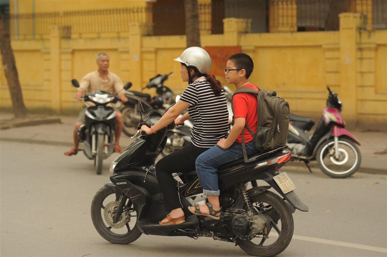 Nhiều phụ huynh đội mũ nhưng lại để con trẻ đầu trần đến trường