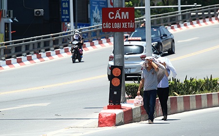 Nhiều người đi qua đoạn đường này phải dùng áo che đầu