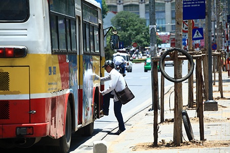 Nhiều người đi qua đoạn đường này phải dùng áo che đầu