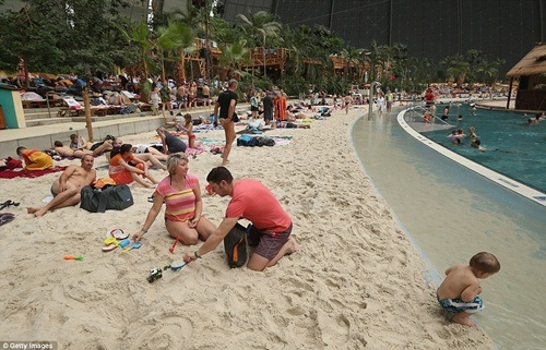 Công viên nước khổng lồ nằm gọn trong... nhà chứa máy bay - 6 Du khách thảnh thơi nghỉ ngơi trên bãi cát nhân tạo trắng phau