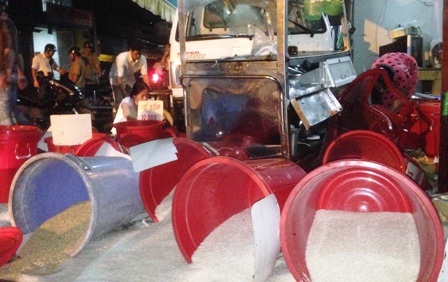 Chiếc xe bán cơnm bị đẩy xa nhiều mét và vựa bán gạo bị xe hất văng tung tóe.