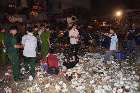Lực lượng chức năng khám nghiệm hiện trường vụ nổ, các chai phân vi sinh nằm ngổn ngang