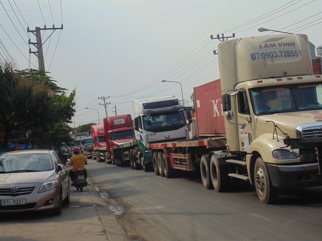 Dòng
xe container theo hướng từ KCN Sóng Thần đi cảng Tân Vạn không thể di chuyển do
kẹt đường