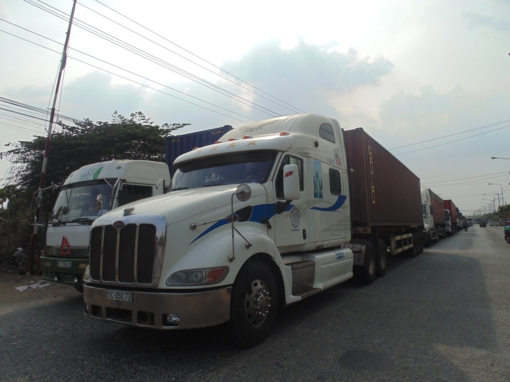Dòng
xe container theo hướng từ KCN Sóng Thần đi cảng Tân Vạn không thể di chuyển do
kẹt đường