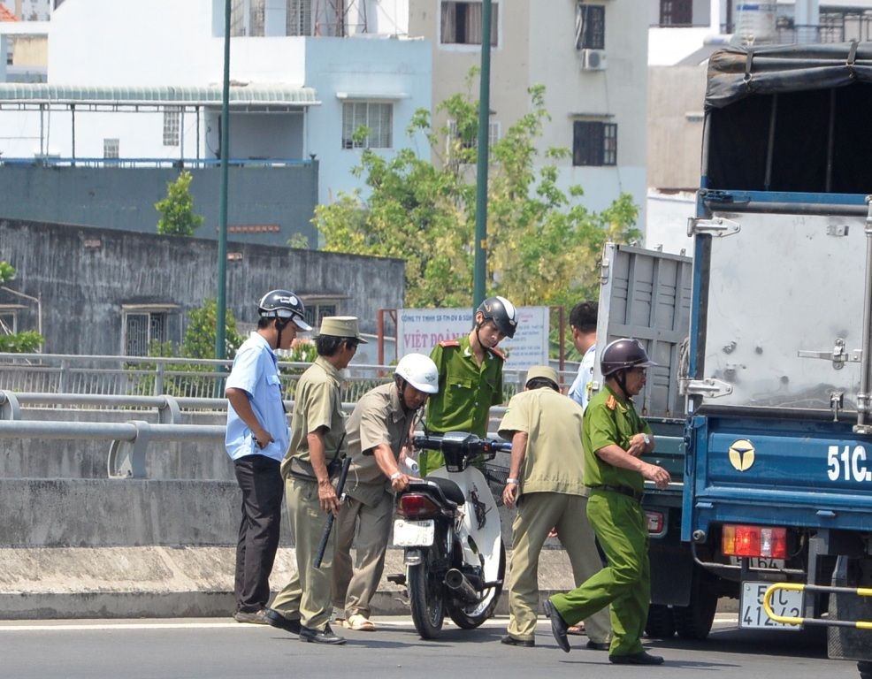 Công an chuyển chiếc xe gắn máy của nghi can về trụ sở để điều tra