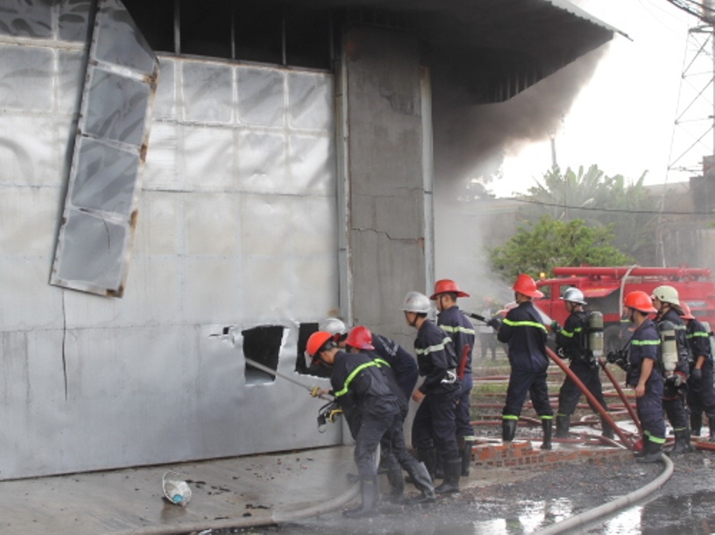 Phá tôn tường để phun nước vào bên trong xưởng.