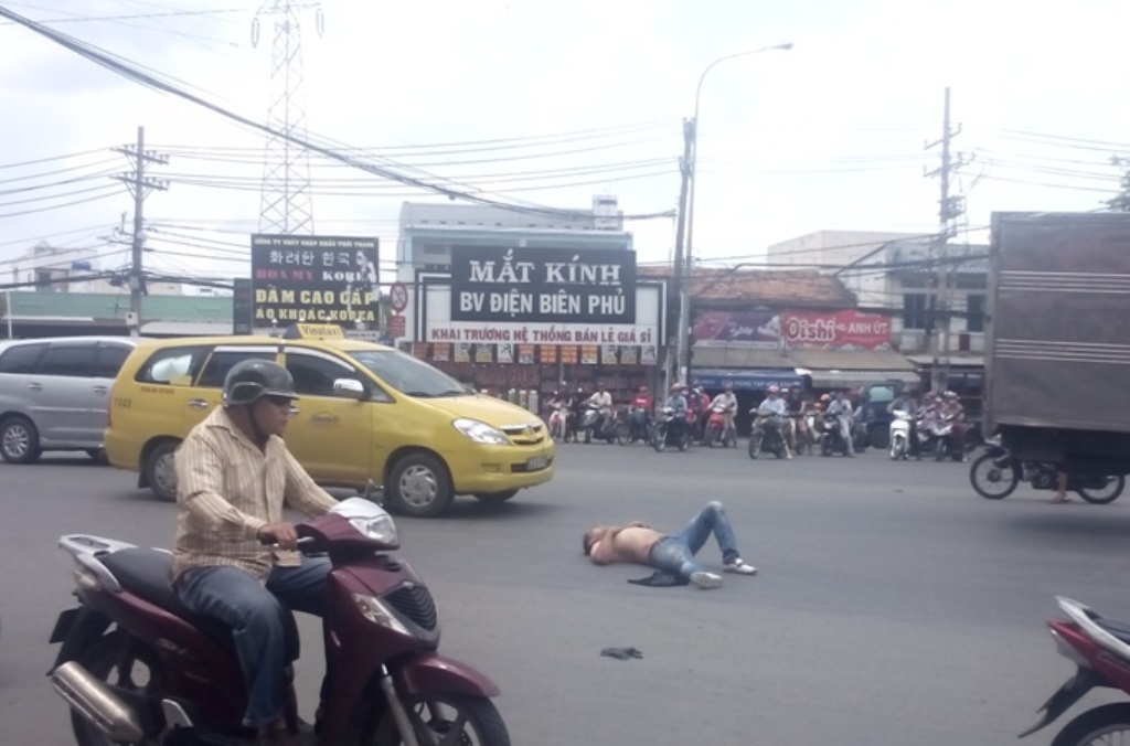 Thanh niên nước ngoài nghi ngáo đá, dọa giết tài xế taxi - 1 Thanh niên cởi áo nằm giữa đường