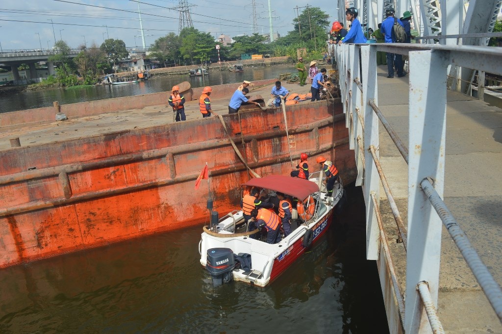 Lực lượng chức năng tiến hành bơm nước để giải cứu chiếc sà lan