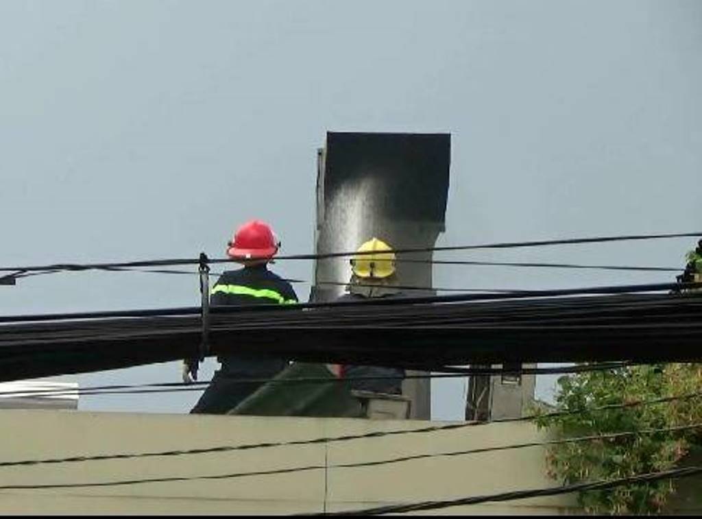 Lính cứu hỏa phun bọt khí vào ống khói để làm mát