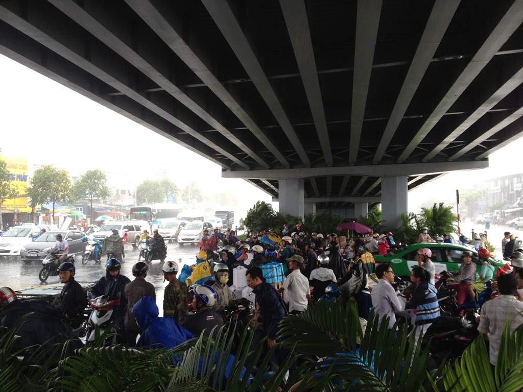 Người dân trú mưa dưới chân cầu vượt thép Hàng Xanh