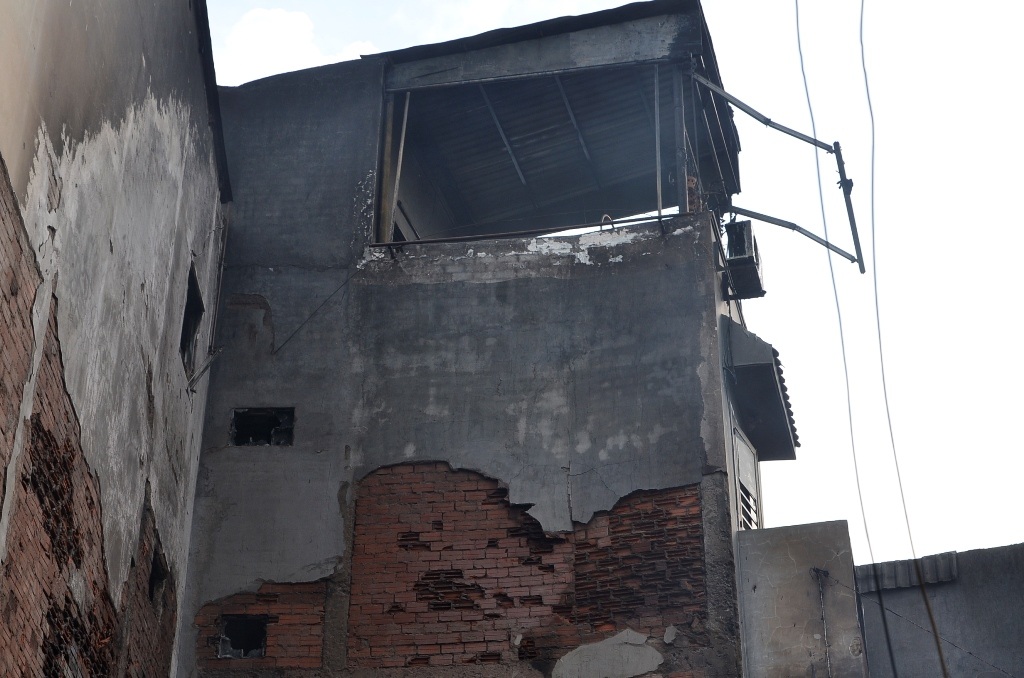 Tường của các căn nhà xung quanh bị cháy đen, hư hỏng