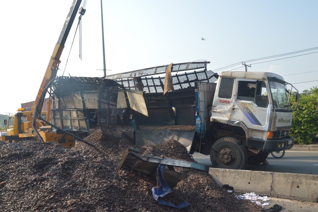 Hiện trường xe tải chở vỏ hạt điều tràn ra đường