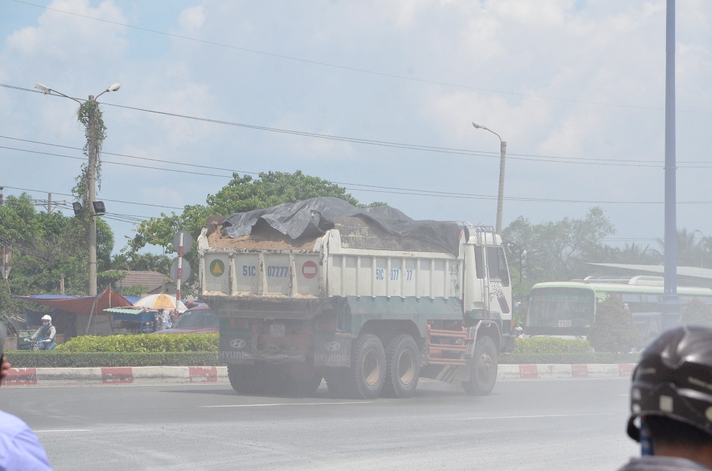 Những xe ben chở đất, cát che đậy không đảm bảo khiến vật liệu rơi vãi xuống đường.