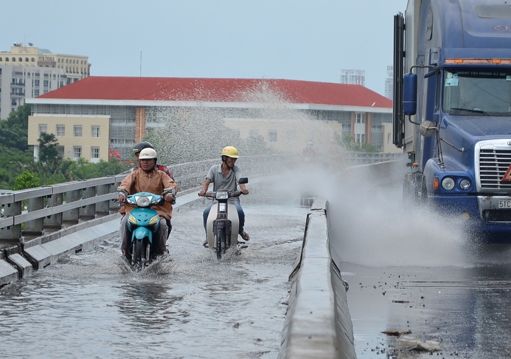 Nhiều người đi xe máy bị nước bắn tung tóe.