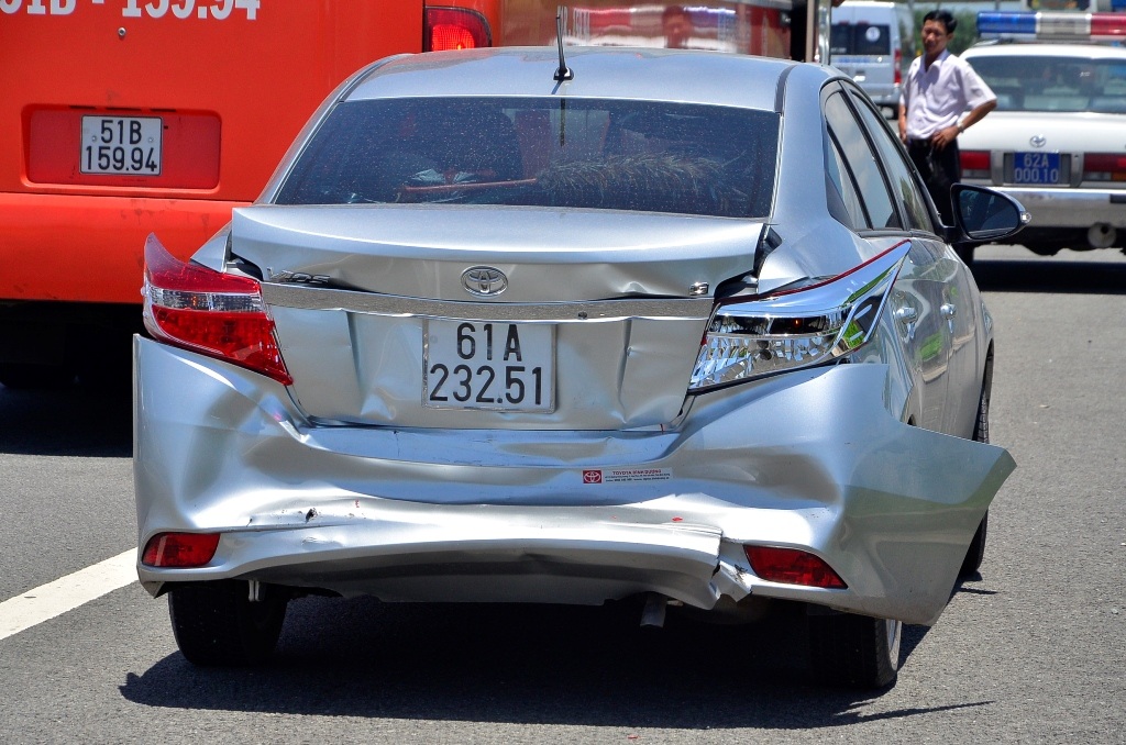 Chiếc xe 4 chỗ bị tông móp đuôi khi chạy chậm để xem vụ tai nạn.