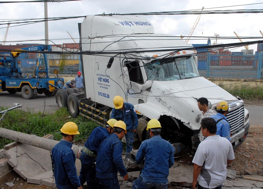 Nhân viên điện lực có mặt để khắc phục sự cố do chiếc container gây ra.