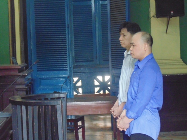 Bị cáo Trần Thanh Tâm ( mặc áo xanh) và bị cáo Nguyễn Thế Quốc tai phiên tòa xét xử