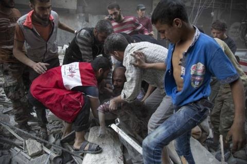 Quân Syria chiếm trung tâm Aleppo, al-Nursa tháo chạy - 2 Người đàn ông khóc ôm cô con gái nhỏ bị vùi trong đống đổ nát sau trận bom tại Aleppo chiều thứ 3. Ảnh: The New York Times