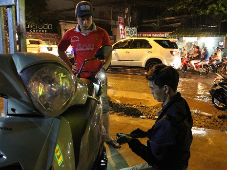 Ba anh em cứu hộ xe máy bị ngập miễn phí ở TPHCM - 8 Trong khi đó, tuyến đường vẫn còn ngập. Lượng xe đưa vào mỗi lúc một nhiều.
