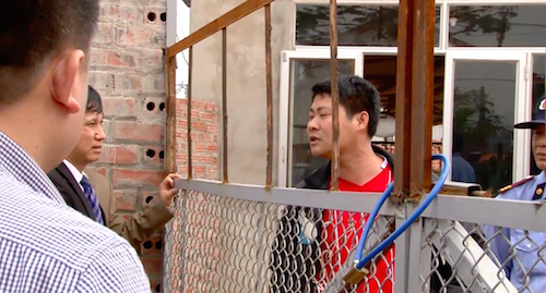 Bộ Tư pháp kiến nghị xử lý sai phạm vụ thi hành án chống lệnh Toà Cấp cao tại Bắc Giang - 2
Người đàn ông áo đỏ xưng là Trưởng Công an xã Lão Hộ đang đứng trong nhà máy tuyên bố không cho ai vào nhà máy.