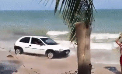 Người đàn ông ném đá lên cửa kính xe ô tô đang di chuyển trên bãi biển