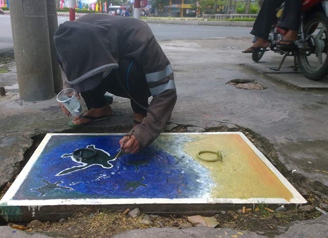 Biến nắp cống thành những... bông hoa xinh xắn - 1 Những nắp cống xấu xí được biến thành những hình vẽ xinh xắn