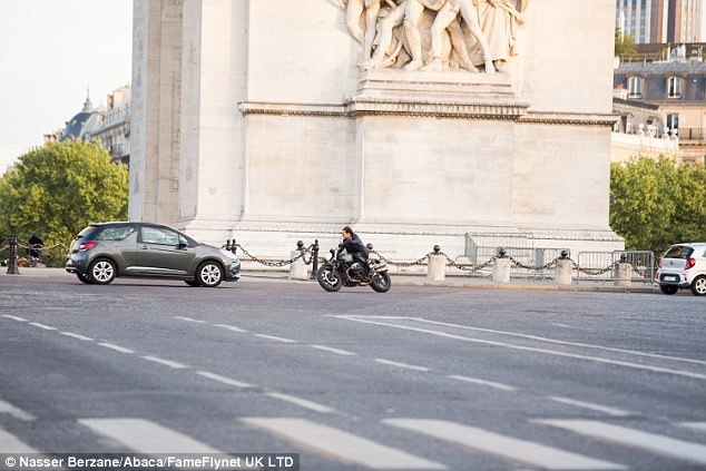 Tom Cruise thực hiện cảnh quay bên cạnh một số chiếc xe hơi.