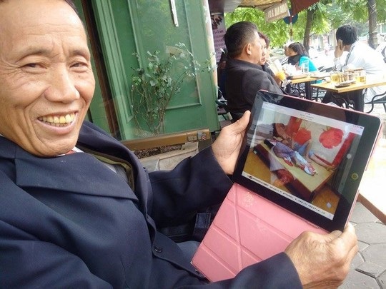 Ông Dương Văn Chuốt mở iPad khoe ảnh bà cả và bà thứ 6 nằm ngủ cùng nhau.