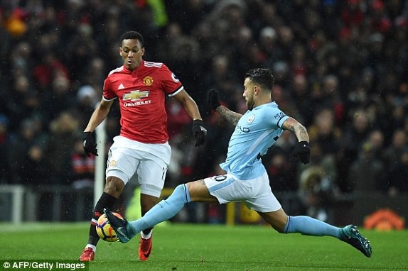 
Otamendi (phải) lao vào ngăn cản Martial đi bóng
