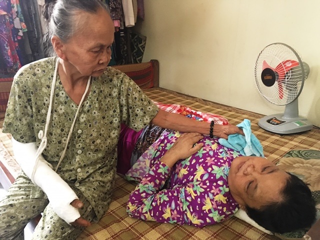 Thiếu 70 triệu đồng, mẹ liệt sĩ đau đớn nhìn con chờ… chết - 3 Còn 1 tay bà Nghĩa cũng ráng chăm sóc cho đứa con gái đang nằm liệt giường