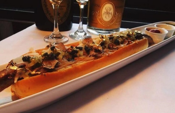 Món hotdog đắt nhất thế giới có giá 2.300 USD. Hotdog là một từ nghe rất nổi bình dân, nhưng nếu bạn nói về chiếc bánh hot dog ở nhà hàng 230 Fifth, New York thì đó lại là một câu chuyện hoàn toàn khác, bởi nó có giá lên đến hơn 2.000 USD, và bạn phải order trước đó 2 ngày. Thịt bò Wagyu, loại thịt bò đắt nhất thế giới, chính là bảo chứng cho giá “trên trời” của chiếc bánh này. Ngoài ra, là nấm cục đen, bơ truffle trắng, nghệ tây, sốt hành caramel Vidalia, trứng cá loại tốt nhất, vàng lá và còn nhiều nguyên liệu đắt tiền khác hơn nữa.