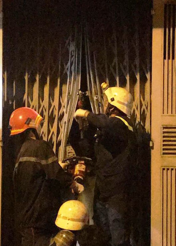 Giải cứu 3 người mắc kẹt trong đám cháy giữa đêm khuya - 2 Do căn nhà bị khoá trái nhiều lớp cửa sắt kiên cố, lực lượng Cảnh sát PCCC đã phải dùng thiết bị chuyên dùng để phá cửa.