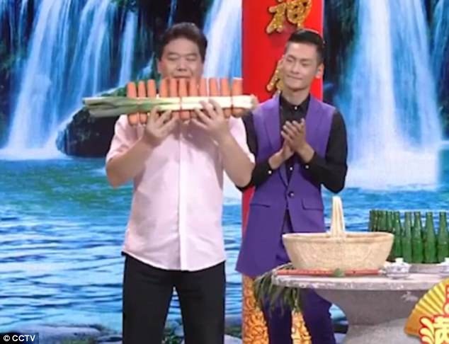 Người đàn ông 48 tuổi đã tự học cách chế tạo và chơi nhạc cụ làm từ rau củ. Trong ảnh, anh Nan đang thổi sáo từ món nhạc cụ làm từ các củ cà rốt và tỏi tây.