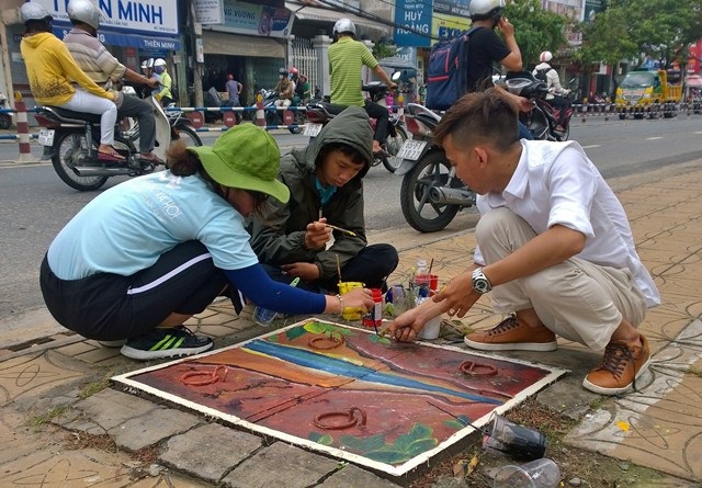 Biến nắp cống thành những... bông hoa xinh xắn - 6 Đoàn thanh niên phường Thới Bình cùng các bạn sinh viên trường ĐH Kiến Trúc TPHCM cơ sở Cần Thơ đang vẽ lên các nắp cống.